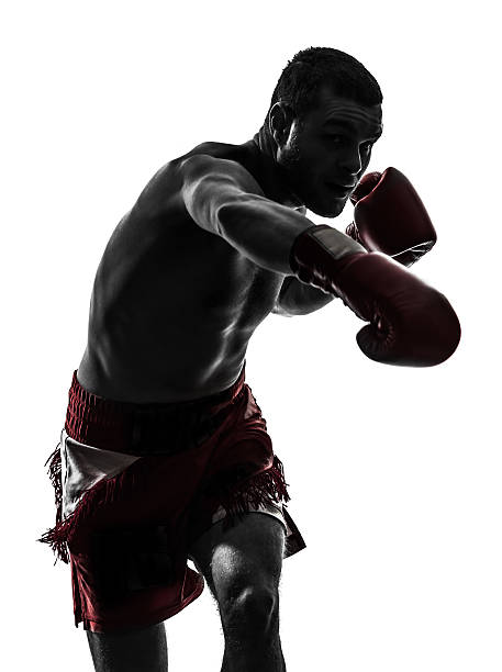 un homme exerçant la boxe thaï silhouette - sport de combat photos et images de collection