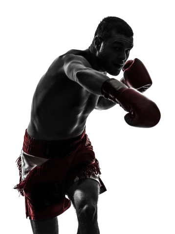 one caucasian man man exercising thai boxing in silhouette studio on white background
