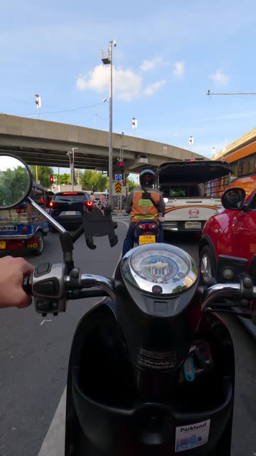 Hyperlapse of motorcycle riding on road next to BTS Skytrain in Bangkok