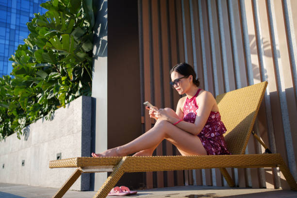 istock Woman in swimsuit using smartphone 1783990094