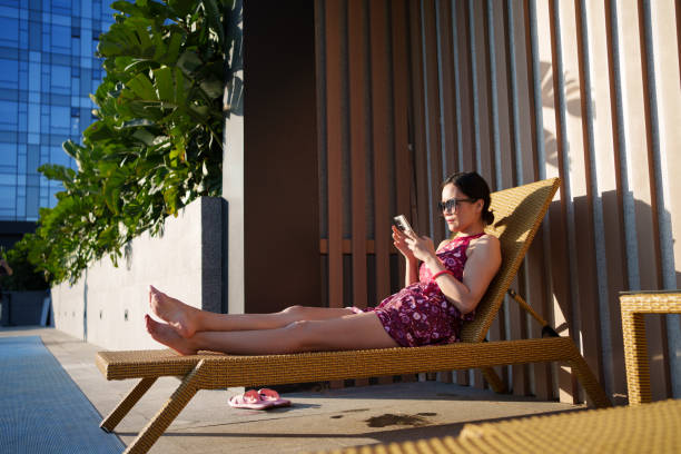 istock Woman in swimsuit using smartphone 1783990143