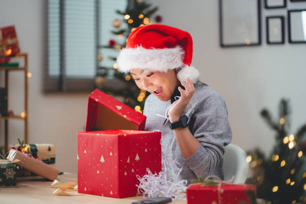 istock Asian woman having fun opening gift boxes on Christmas day. 1783998716