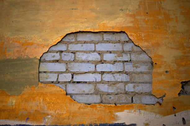 istock Photo a yellow plastered wall and white bricks. 1783998737