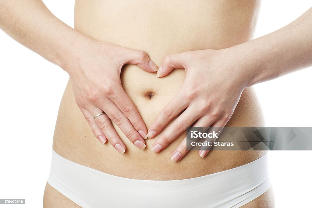 Woman shows the heart symbol on her body Woman shows the heart symbol on her body. Isolated on white background. Abdomen Stock Photo