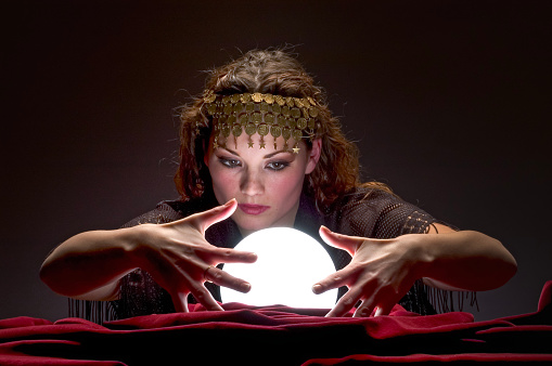 Fortune teller with Cristal ball on red velvet. Looking down.