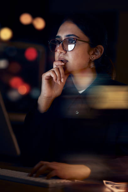 Woman, night office and thinking at computer for seo planning, pc research or ideas in dark. Female worker, desktop technology and overtime with online network, data solution and internet strategy