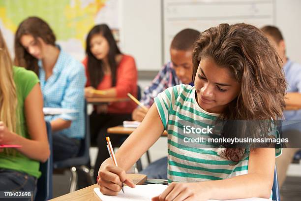 Female Pupil Studying At Desk In Classroom Stock Photo - Download Image Now - Educational Exam, Education, Teenager