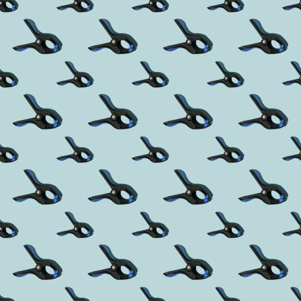 istock Seamless pattern of black multipurpose clamps with blue grips. Blue background. 1784043615