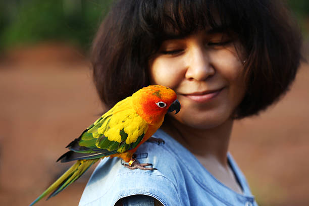 istock woman and parrot sun conure 178404863