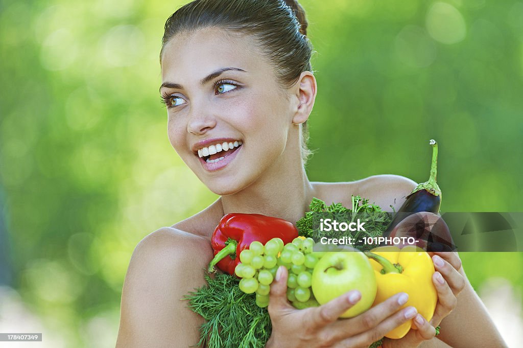 happy beautiful young woman with vegetables Portrait of happy beautiful young woman with vegetables, against background of summer green park. Adult Stock Photo