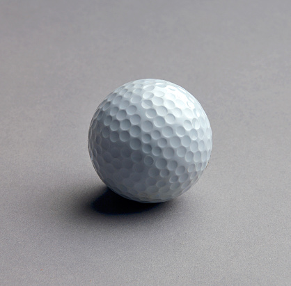 High angle view Golf ball on a grey background, studio shot.