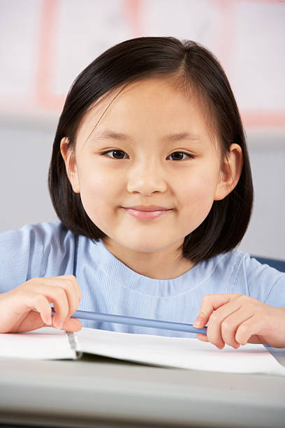 istock Female Student Working At Desk In Chinese School Classroom 178408799