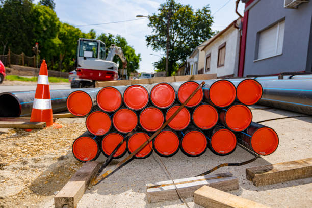 istock Pack of polymeric HDPE water pipes and few warning traffic cones 1784091055