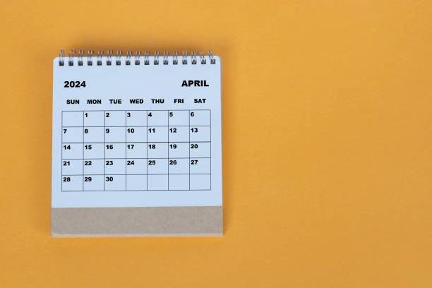 istock April 2024 desk calendar on yellow background. Directly above. Flat lay. 1784093306