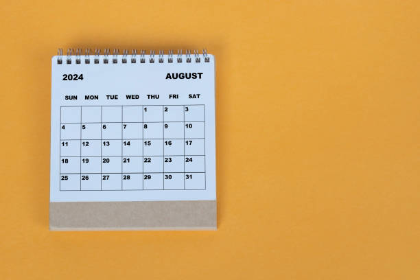 istock August 2024 desk calendar on yellow background. Directly above. Flat lay. 1784093308
