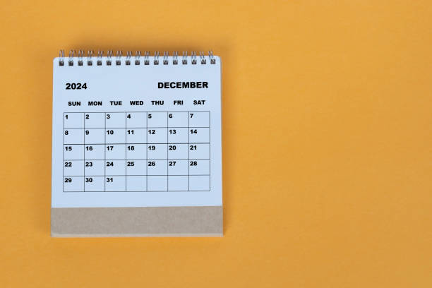 istock December 2024 desk calendar on yellow background. Directly above. Flat lay. 1784093309