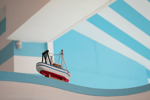 Toy Boat with a White and Blue Wall in the Background. Architectural Detail. Milano, Italy