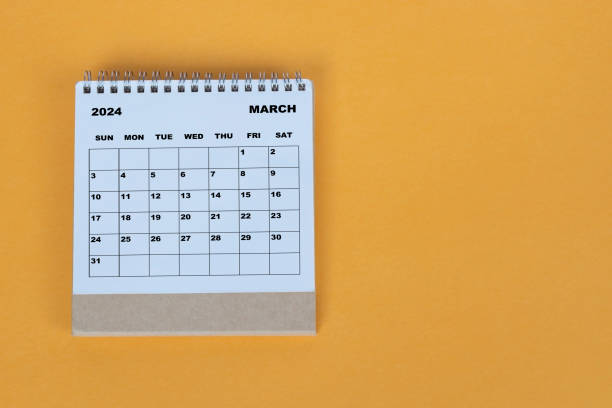 istock March 2024 desk calendar on yellow background. Directly above. Flat lay. 1784093848