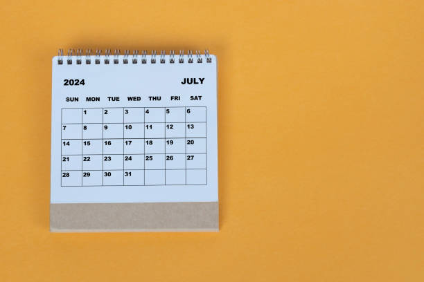 istock July 2024 desk calendar on yellow background. Directly above. Flat lay. 1784094381