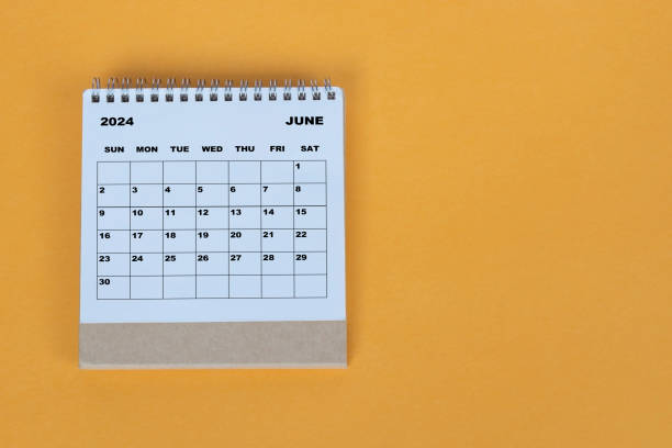 istock June 2024 desk calendar on yellow background. Directly above. Flat lay. 1784094391