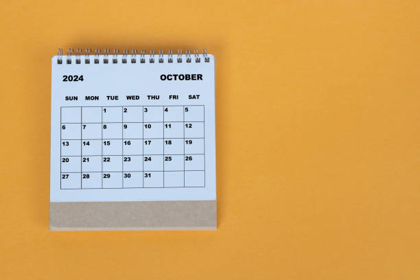 istock October 2024 desk calendar on yellow background. Directly above. Flat lay. 1784094981