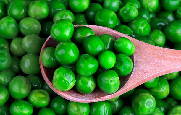 istock Fresh wet green peas on the wooden spoon 178409632