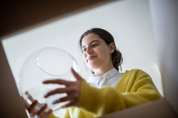 Woman opening fragile parcel at home, opening delivery box.