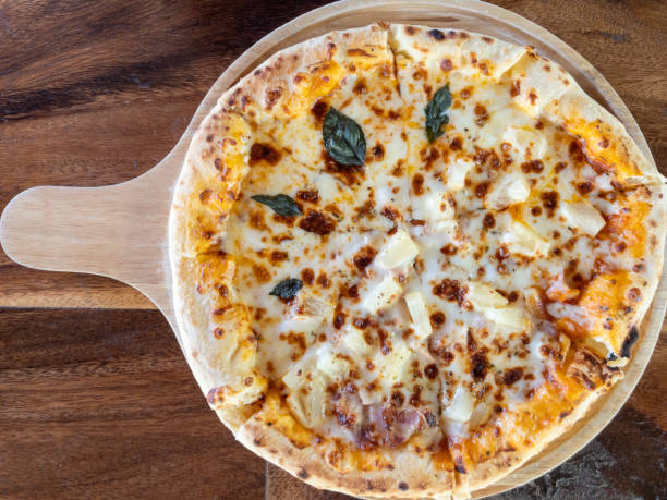 Above view of the margherita pizza. Above view of the margherita pizza served on the wooden pan from the homemade kitchen, above view with the copy space. pizza topping stock pictures, royalty-free photos & images