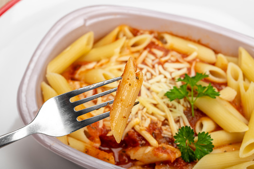 Fork lifting pasta from a ready meal