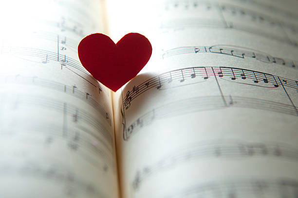 Love for music. heart shape on a music note book. shallow DOF musical note photos stock pictures, royalty-free photos & images
