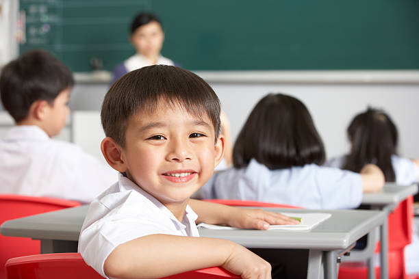 portret mężczyzny uczeń pracuje przy biurku w szkole chińskiego - elementary student school uniform uniform education zdjęcia i obrazy z banku zdjęć