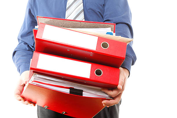 istock Male office worker carrying a stack of files 178412433