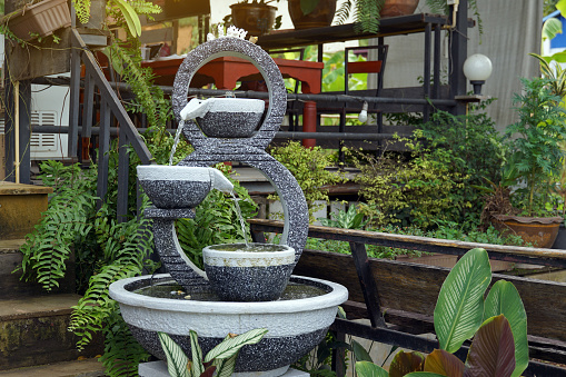 A set of number 8 garden fountain made from fresh stucco with a stone pattern used to decorate the garden in a natural style to make it beautiful according to Feng Shui principles.