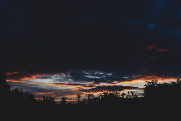 Beautiful sunset sky in dark shades. The sunset breaks through the black clouds..