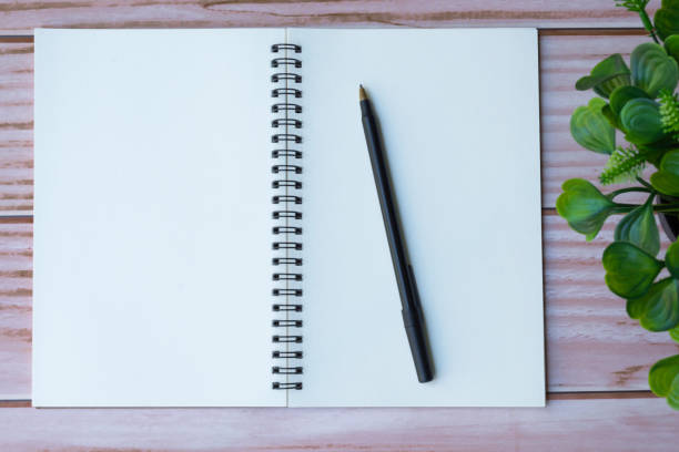istock Directly above view of office desk table with pen, notepad and plant. 1784146537