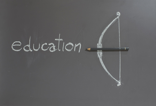 Pencil with bow on blackboard Educational concept
