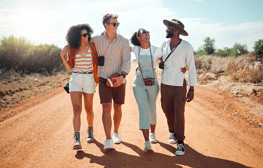 Safari, funny and friends walking in nature during a holiday together in summer. Comic, happy and young group of people on travel vacation in the desert for freedom, adventure and happiness in Kenya