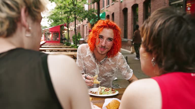 Candid over the shoulder view of friends snacking outdoors