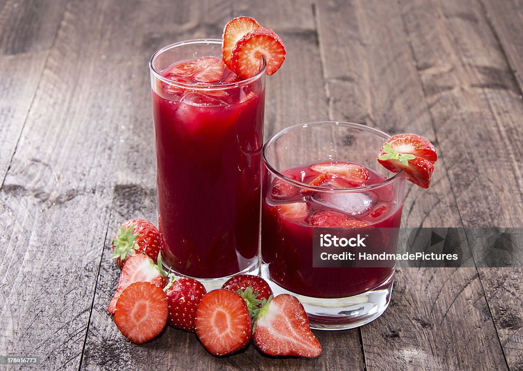 Some glasses with Strawberry Liqueur Some glasses with Strawberry Liqueur on wooden background Strawberry Juice Stock Photo