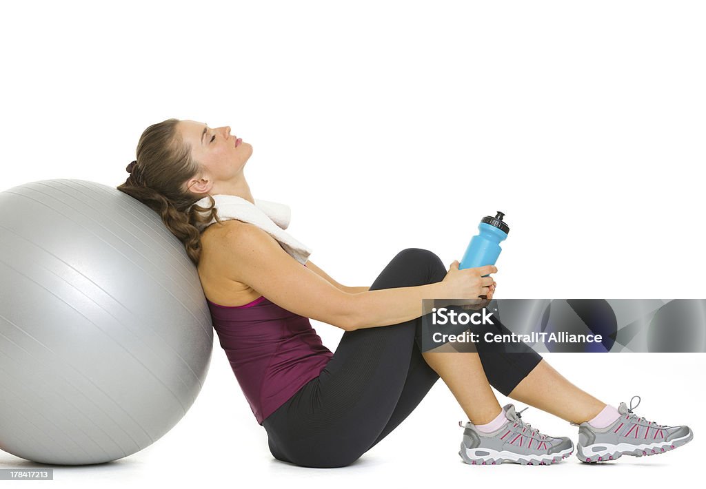 Tired young woman relaxing after workout on fitness ball Tired fitness young woman relaxing after workout on fitness ball Adult Stock Photo