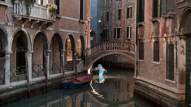 istock Canal in Venice with a boat in the sun 178417725