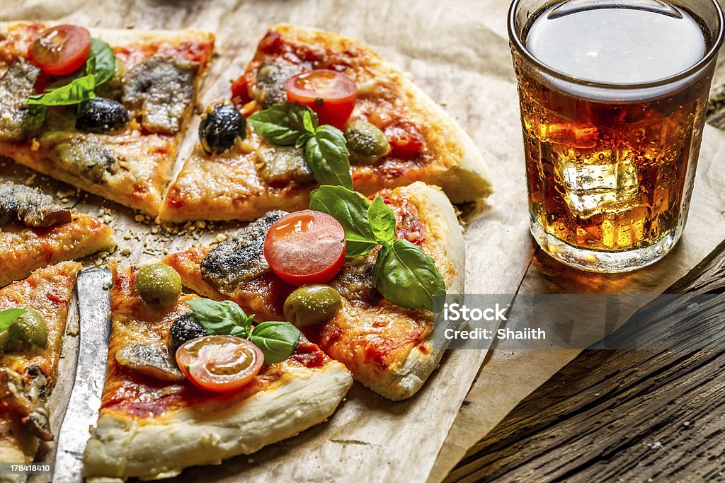 Freshly baked pizza served with a cold drink Freshly baked pizza served with a cold drink. Basil Stock Photo