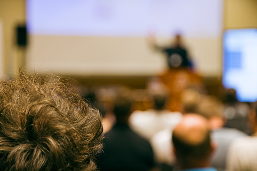 Business conference with unrecognizable audience. Shallow DOF, selective focus.