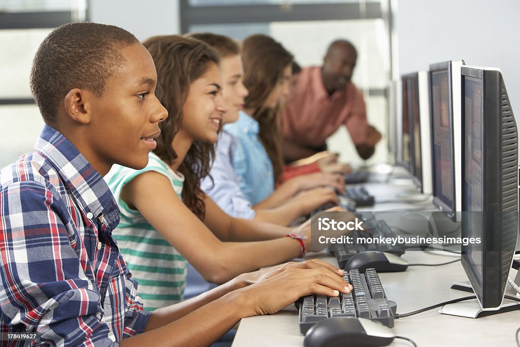 Grupo de estudantes trabalhando em computadores em sala de aula - Foto de stock de Estudante royalty-free