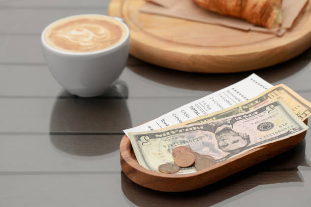 istock Tips, receipt and cup with coffee on wooden table 1784206626
