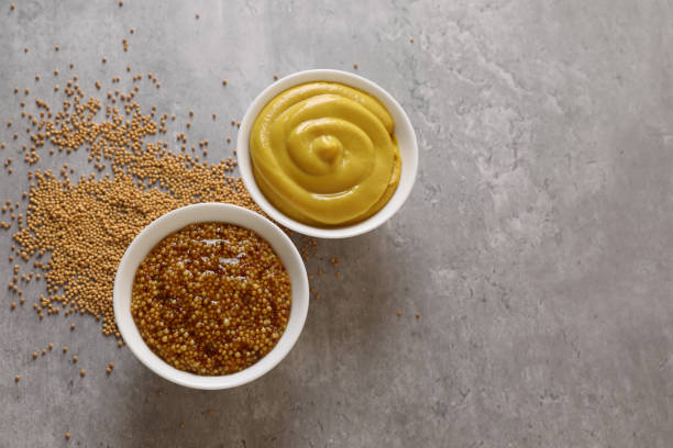 istock Bowls with mustard and seeds on grey table, flat lay. Space for text 1784207219