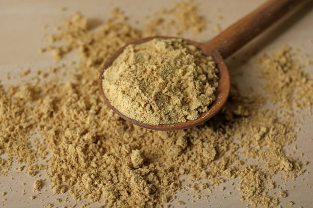 istock Spoon with aromatic mustard powder on wooden table, closeup 1784207855