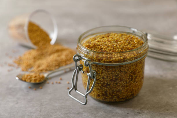 istock Jar of delicious whole grain mustard and seeds on grey table 1784208395