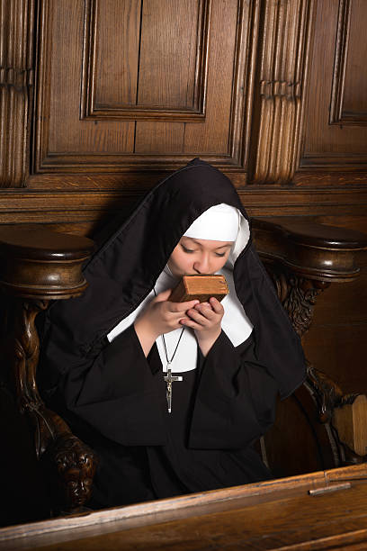 istock Nun kissing prayer book 178421243
