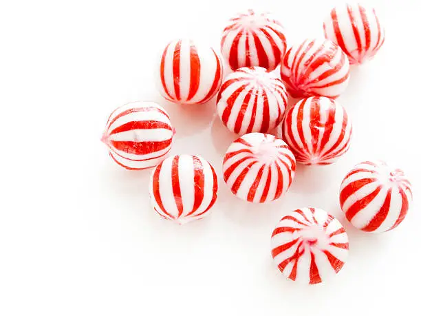 Gourmet white and red peppermint candies on white background.